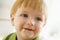 Young boy eating baby food with mess on face