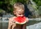 Young boy eating ripe watermelon