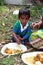 A young boy eats lunch sitting on the ground in Kumrokhali, West Bengal, India