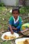A young boy eats lunch sitting on the ground in Kumrokhali, West Bengal, India