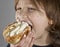 Young boy enjoying a cream bun with almond paste