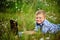 Young boy in field with dandelions with a laptop