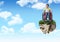 Young boy on floating rock platform in sky in wheelchair