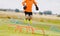 Young boy football soccer goalie on training session jumping high over hurdles