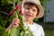 Young boy gardening at home showing his radish harvest