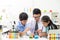Young boy and girl doing science experiment with colorful liquid chemical inside glass tube and beaker. With teacher who teach and