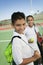 Young boy and girl with tennis equipment on tennis court focus on boy portrait