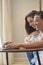 Young boy and girl together at home enjoying laptop computer sitting on the floor smiling and laughing - new life married people