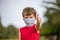 Young boy gives thumbs up while wearing mask