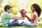 Young boy giving young girl flowers and smiling