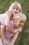 Young boy giving young girl piggyback outdoors