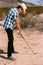 Young boy golfing in the desert