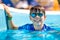 Young boy in googles holding edge of swimming pool. Enjoying time in the refreshing water