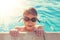 Young boy in googles holding edge of swimming pool vintage