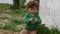 Young boy with green sweater playing outdoor