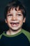 Young boy grinning with missing teeth