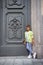 Young boy in hat posing in the milanese street near ancient door. Cute happy 6 years old boy posing in Milan, Italy. Kid`s street