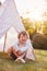 Young Boy Having Fun Inside Tent Or Tepee Pitched In Garden