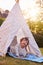 Young Boy Having Fun Inside Tent Or Tepee Pitched In Garden