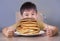 Young boy having pancakes breakfast. 8 years old happy excited child sitting on table eating huge pile of pancakes smiling in