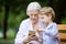 Young boy and his great grandmother using smartphone outdoors