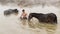Young boy and his horse in thermal water, Guroymak, Bitlis