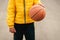 Young boy holding in hands Basketball sport Young little caucasian sports kid playing leading the orange ball street dribbling