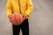 Young boy holding in hands Basketball sport Young little caucasian sports kid playing leading the orange ball street dribbling