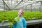 Young boy holding lettuce in greenhouse