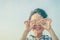 Young boy holding shell over sky background