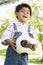 Young boy holding soccer ball outdoors smiling