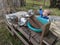 Young boy holding a whisk and playing in a mud kitchen