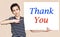 Young boy holding white board with thank you message