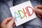 Young boy holds ADHD text written on sheet of paper