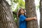 Young boy hugging a tree branch. Little boy kid on a tree branch. Child climbs a tree.