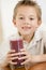 Young boy indoors drinking juice