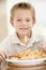 Young boy indoors eating fish and chips