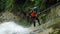 Young Boy With Instructor Rappelling A Huge Waterfall In Ecuadorian Andes