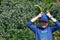 A young boy keeping two broad beans pods above his head pretending to be a rabbit. Children gardening. Easter rabbit