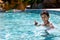 Young boy kid child eight years old having fun in swimming pool leisure activity thumbs up