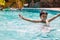 Young boy kid child eight years old splashing in swimming pool having fun leisure activity