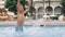 Young boy kid child splashing in swimming pool having fun leisure activity.