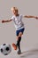 young boy kneeing a soccer ball isolated in studio