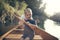 Young boy learning to paddle canoe with his dad