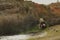 Young boy with long hair looking into waterhole in beautiful Australian bush setting