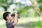 Young boy looking birds in forest