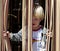 Young boy looking out from behind curtain