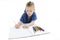 Young boy lying on floor with pencils on a sketch book with a look of concentration, close up view.