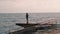 Young boy making photo of stormy sea. Man takes picture of ocean. Lonely boy standing at promenade