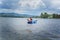 Young boy paddling blue and white kayak in harbour